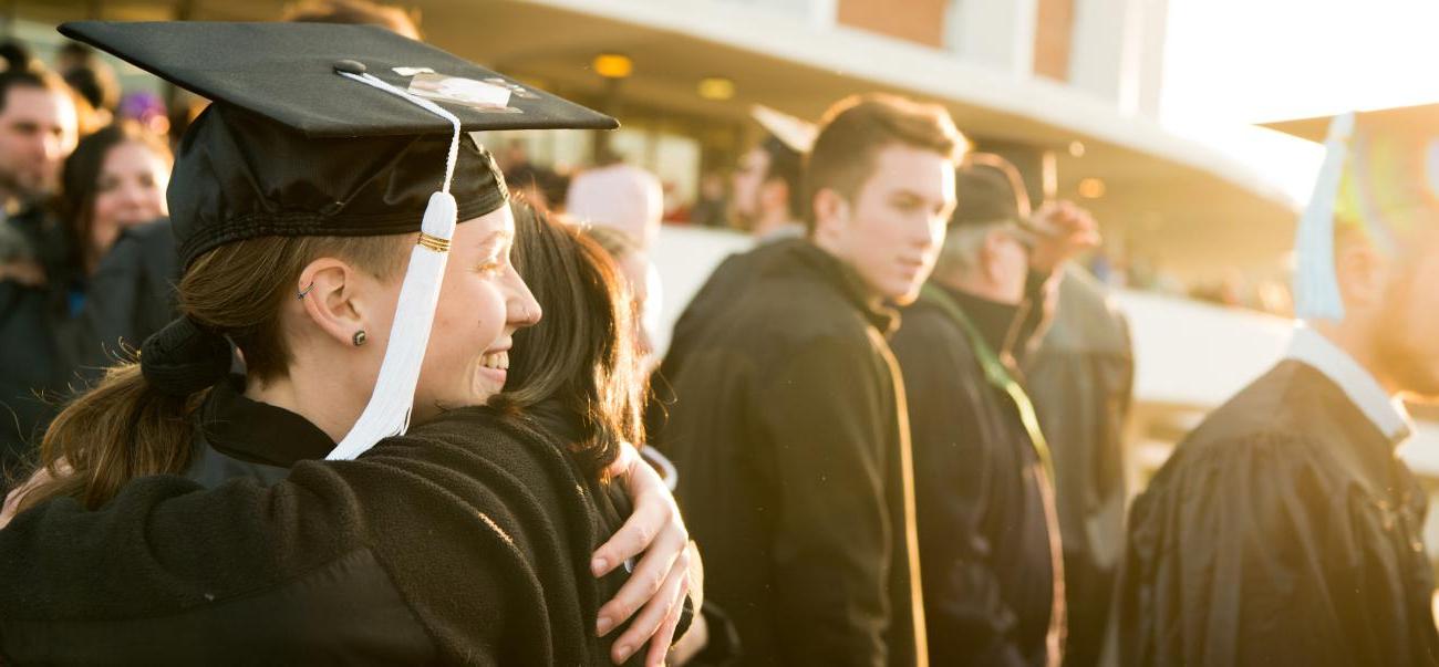 Two Ohio University students hug after Commencement