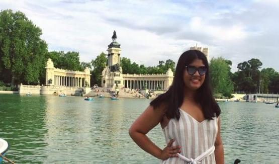 Reiya Bhat, HTC alumna, standing in front of water and monument in India